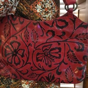 Red & black thin tooled leather bag.